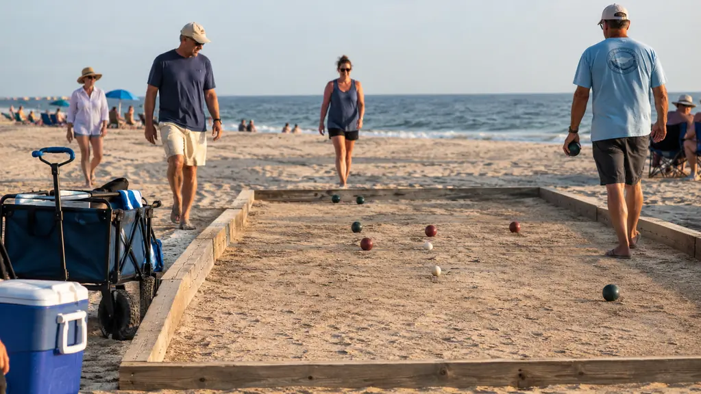 Players walking between throws on a beach bocce court.
