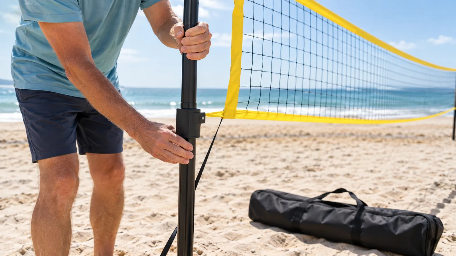 Hands adjusting a portable volleyball net pole on the sand