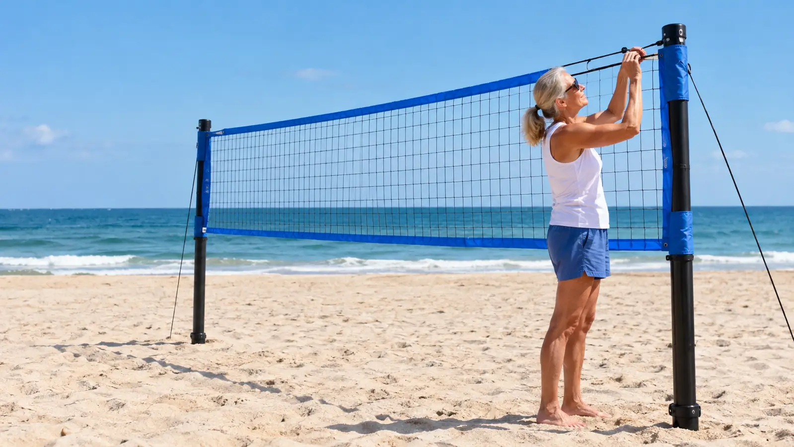 The Zdgao volleyball net system set up on flat sand with the net tensioned at play height