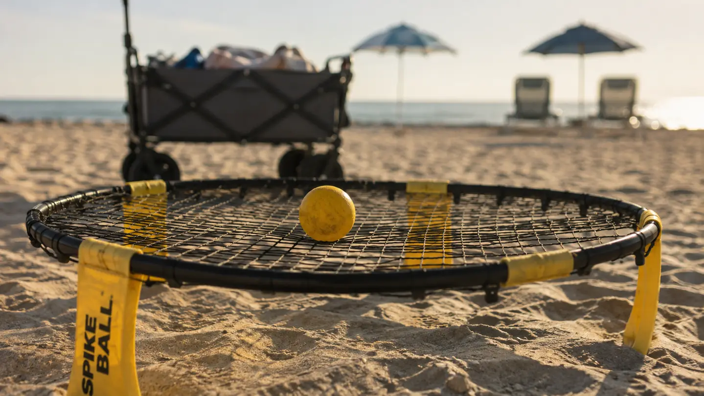 The round net set up on the sand with a ball resting on the net